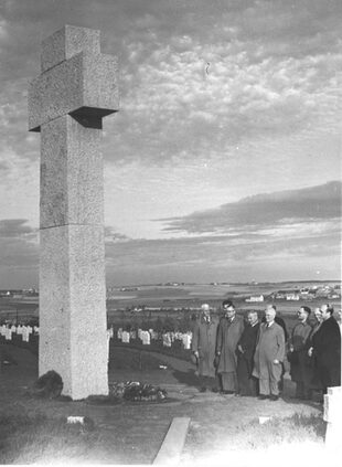 Die undatierte schwarz-weiße Fotografie stammt aus den frühen 1950er-Jahren. Der Besuchergruppe vor dem Hochkreuz eröffnet sich noch der unverstellte Blick in die weite Landschaft. Rechts unterhalb des Horizonts liegt Hürtgen.