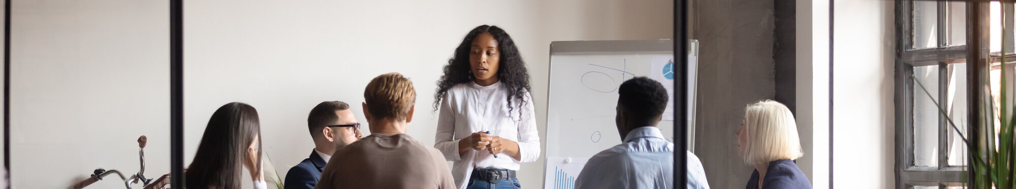 Confident african female trainer giving educational workshop at office.