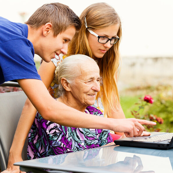 Motivbild Jugendliche helfen Seniorin am PC [Foto: ©Barabas Attila - stock.adobe.com]
