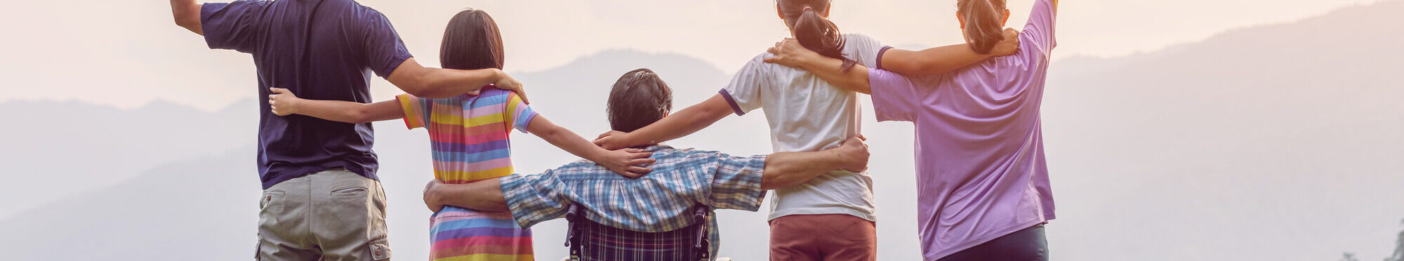 Rückansicht einer Familiengruppe mit einem Mann im Rollstuhl