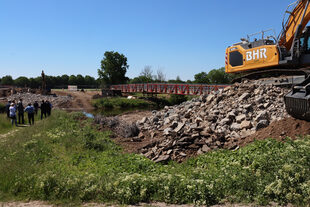 Ein Bagger bewegt Bauschutt an der Baustelle in Merken.