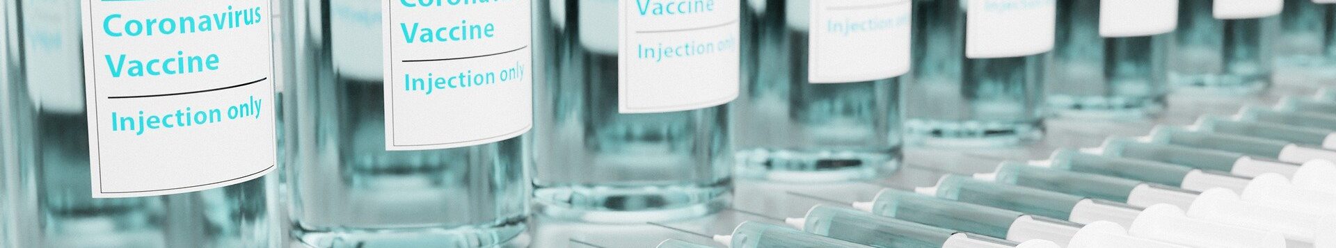 Corona Impfstoff in Flaschen und Spritzen aufgereiht