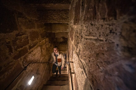 Ein Mann kommt die Treppe im Burgenmuseum hoch