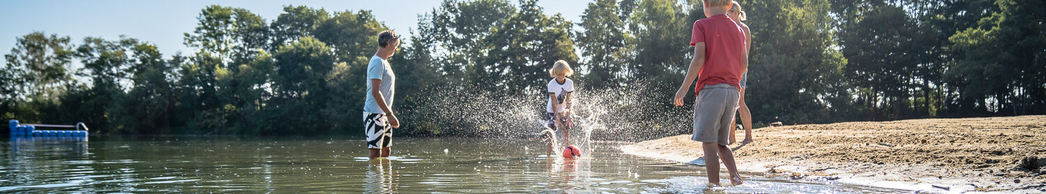 Kinder spielen im Wasser mit einem Ball