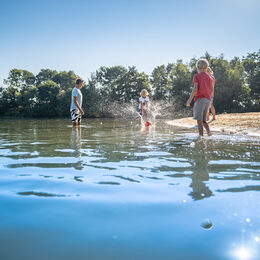 Kinder spielen im Wasser mit einem Ball