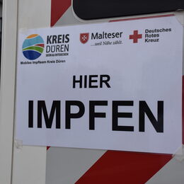 Ein Schild, auf dem "Hier Impfen" zu lesen ist