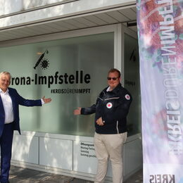 Landrat und DRK-Mitarbeiter vor der Impfstelle des Kreises Düren