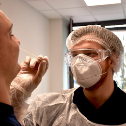 Ein Mann testet einen anderen Mann mit einem Stäbchen auf das Coronavirus