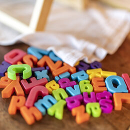Bunte Buchstabendmagnete liegen auf einem Tisch
