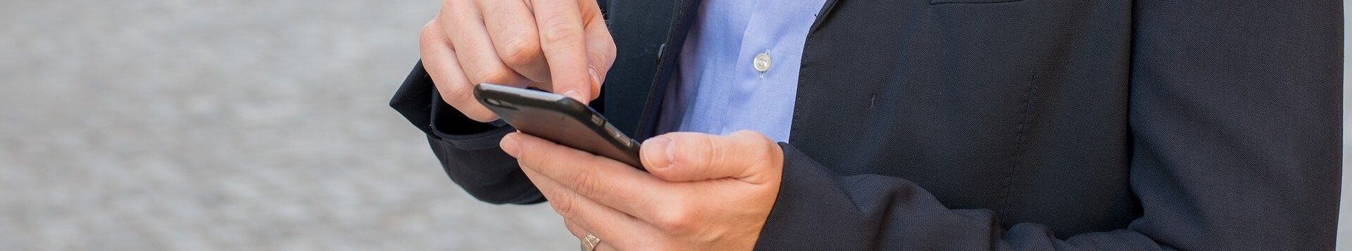 Ein schick gekleideter Mann mit Smartphone in der Hand