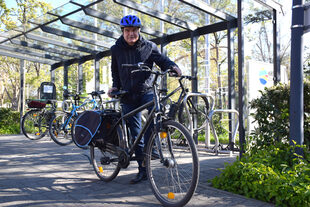 Ein Mann steht neben seinem Fahrrad.