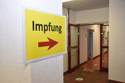 Ein Schild mit einem Pfeil und der Aufschrift  "Impfen" zeigt die Richtung der Impfzimmer an.