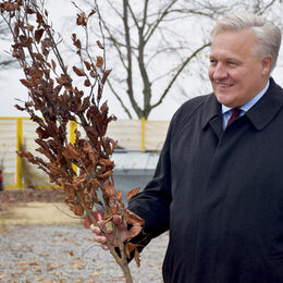 Landrat Wolfgang Spelthahn hält einen jungen Baum in der Hand.