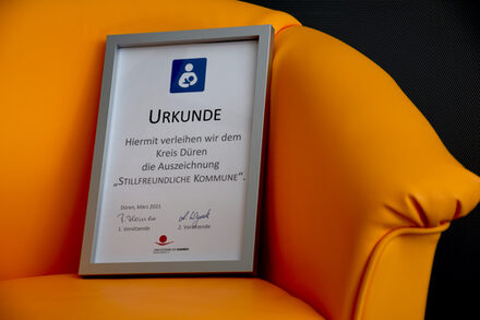 Gelber Stuhl mit einer Urkunde darauf