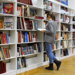 Frau vor einem Bücherregal.