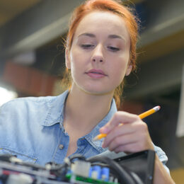 Eine junge Frau im Beruf als Feinmechanikerin