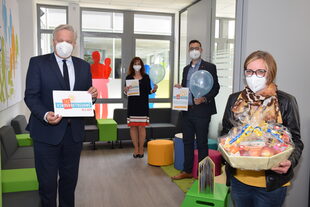 Landrat Wolfgang Spelthahn (v.l.) bedankt sich mit einem Geschenkkorb stellvertretend bei Sonja Koglin (v.r.), Leiterin der Kita Sternschnuppe Jülich, für die wertvolle Arbeit. Jugendamtsleitern Elke-Ricken-Melchert (hinten l.) und Christoph Siebertz, vom Vorstand der Kreismäuse AöR, schließen sich dem Dank an.