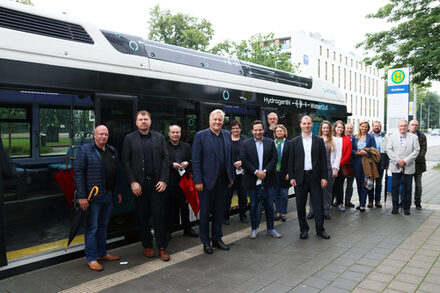 Mehrere Menschen stehen vor dem Wasserstoff-Bus