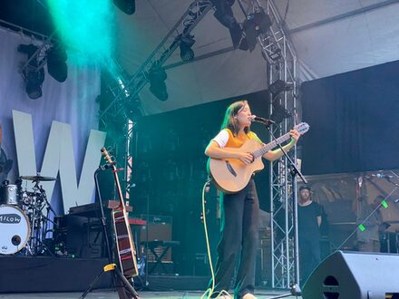 Sängerin OSKA auf der Bühne mit Gitarre