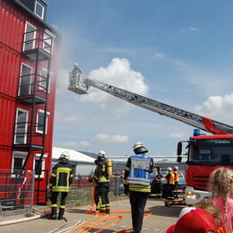 Das Publikum beobachtet eine Übungsaktion von Feuerwehrleuten.