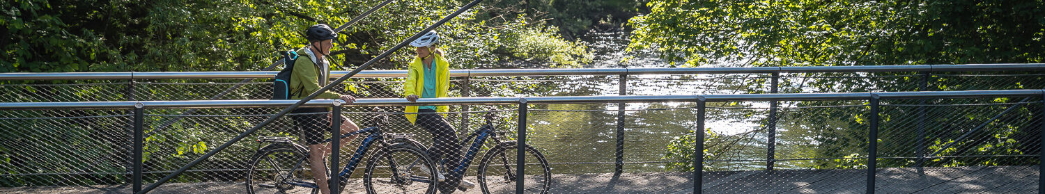 Radfahrer auf einer Brücke, die über die Rur führt