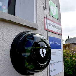 Ein Defibrillator hängt an der Wand der Grundschule in Drove.