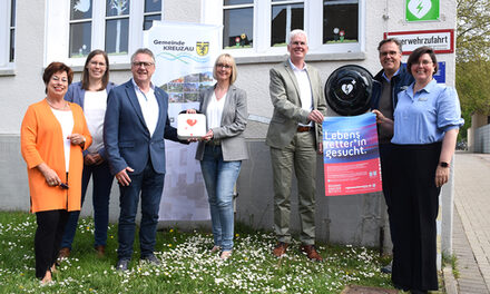 Sieben Menschen präsentieren den neuen Defibrillator in Kreuzau.