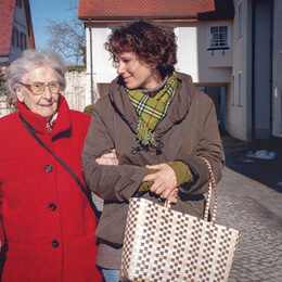 Frau geht mit älterer Dame spazieren