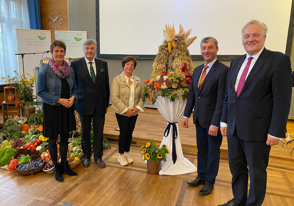 Das Bild zeigt fünf Personen an einer kunstvoll gestalteten Erntekrone