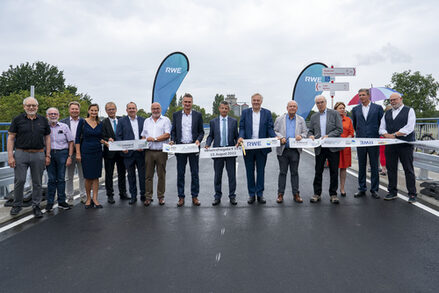 Die regionalen Vertreter stehen auf der Brücke mit dem Eröffnungsband.