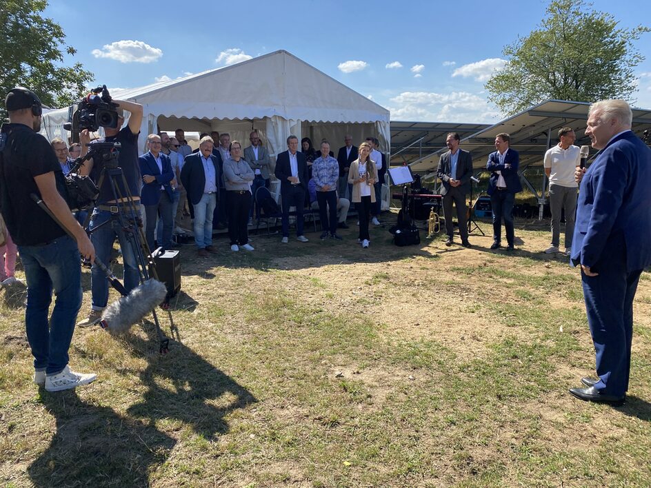 Das Bild zeigt den Landrat bei seiner Rede und rund 30 Personen, die vor einem Zelt zuhören