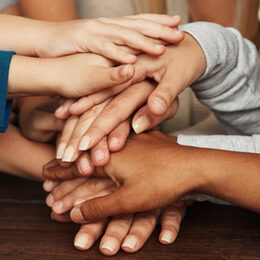 Viele Kinder einer Grundschule bilden einen Stapael Hände als Teamwork Konzept