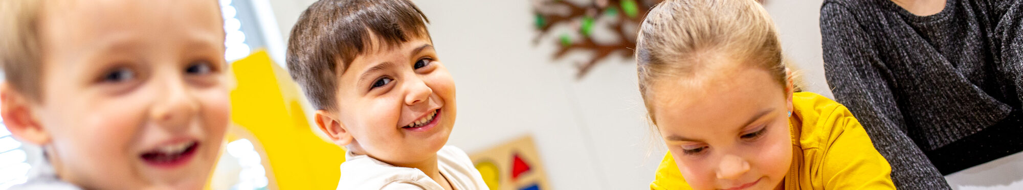 Kinder spielen drinnen im Sand und lachen