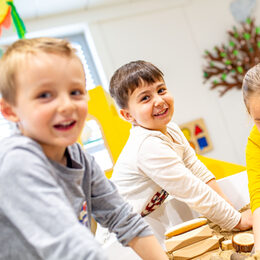 Kinder spielen drinnen im Sand und lachen