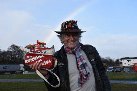 Peter Borsdorff vor einem Regenbogen mit seiner Dammeldose