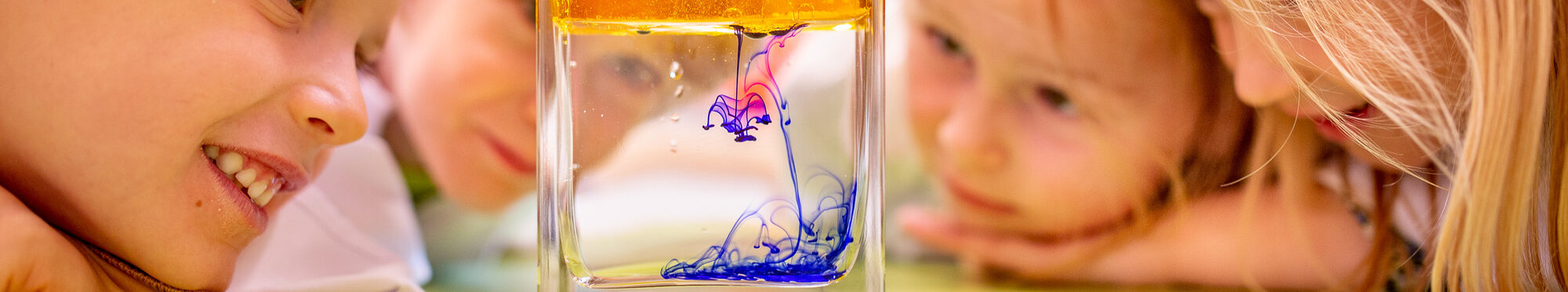 Kinder gucken Farben in Glas an.
