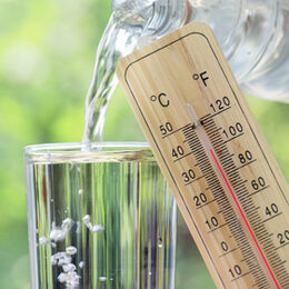 Thermometer und ein Glas Wasser