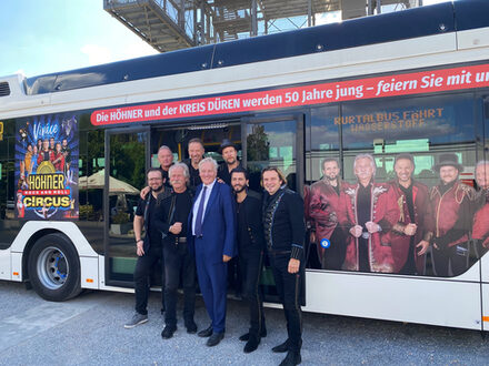 Landrat Wolfgang Spelthahn (3.v.l.) mit den Höhnern vor dem beklebten Wasserstoffbus.