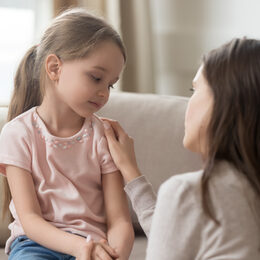 Loving mom talking to upset little child girl giving support