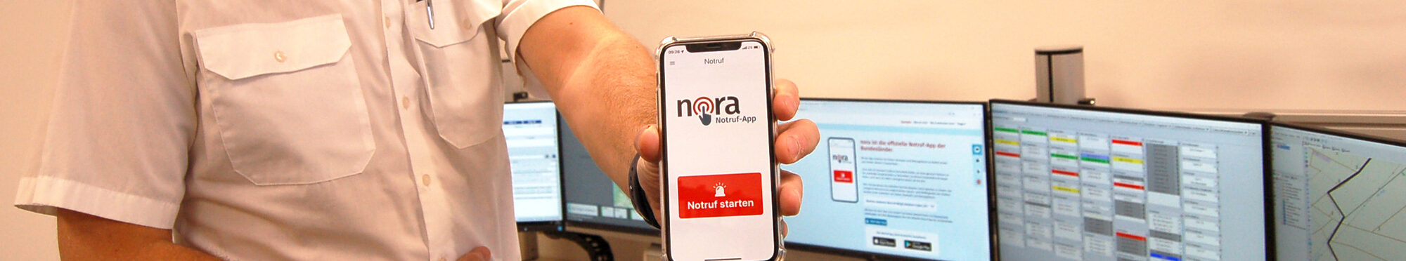 Stefan Nepomuck, Leiter der Leitstelle des Kreises Düren, hält sein Smartphone mit der Nora-App in die Kamera.