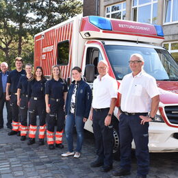 Landrat mit neuen Azubis vor dem Rettungswagen