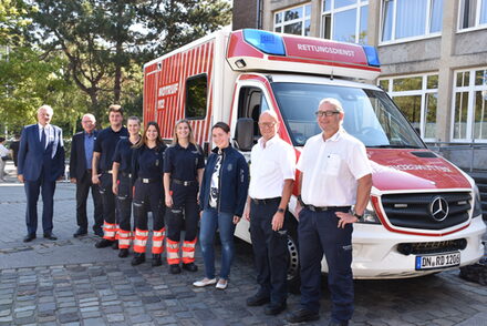 Landrat mit neuen Azubis vor dem Rettungswagen