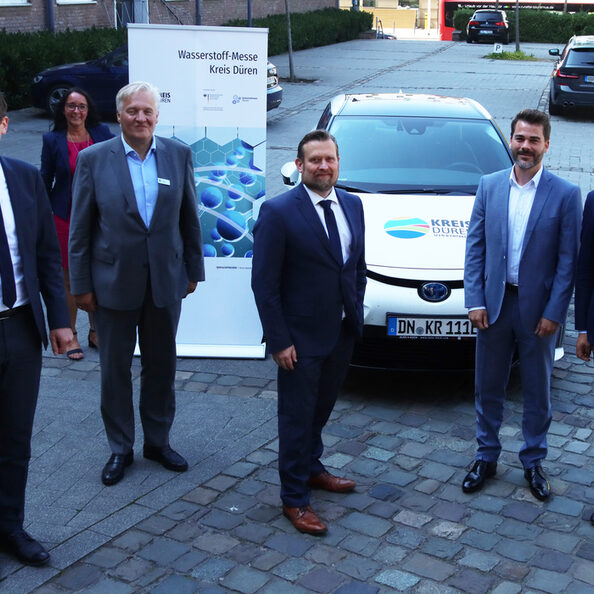 Sechs Personen stehen vor einen Auto