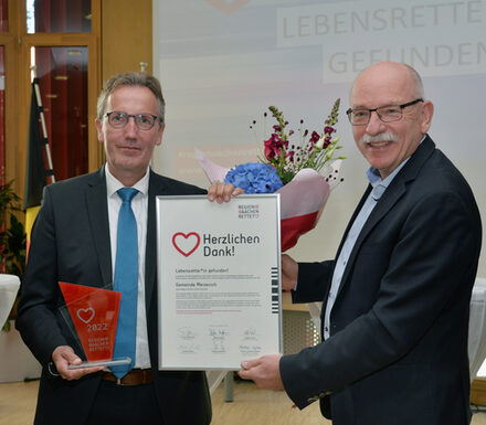 Bürgermeister Georg Gelhausen nimmt die Auszeichnung für Gemeinde Merzenich von Peter Kaptain entgegen.