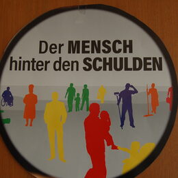 Ein Schild hängt an einer Wand.