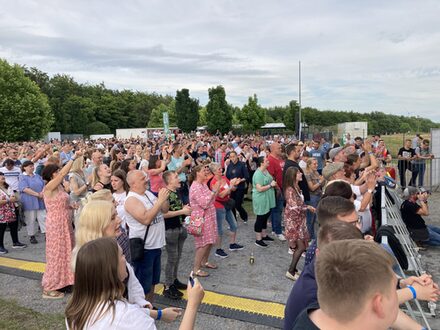 Viele Zuschauer blicken zur Bühne und singen mit.