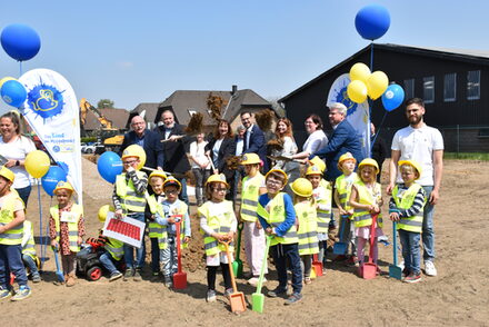 Die Vertreter und Kinder beim Spatenstich