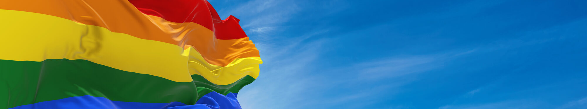 Gay Pride flag waving in the wind at cloudy sky. Freedom and love concept. Pride month. activism, community and freedom Concept. Copy space. 3d illustration,
