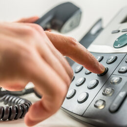 Closeup of male hand dialing a phone number making a business or personal phone call.