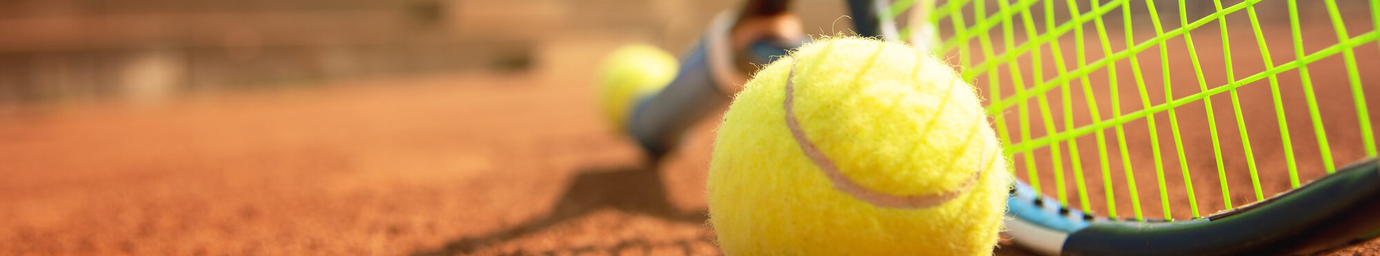 Tennisschläger und -ball auf einem Tennisplatz